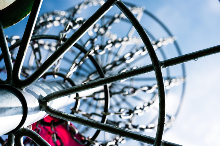 A disc golf basket against the sky
